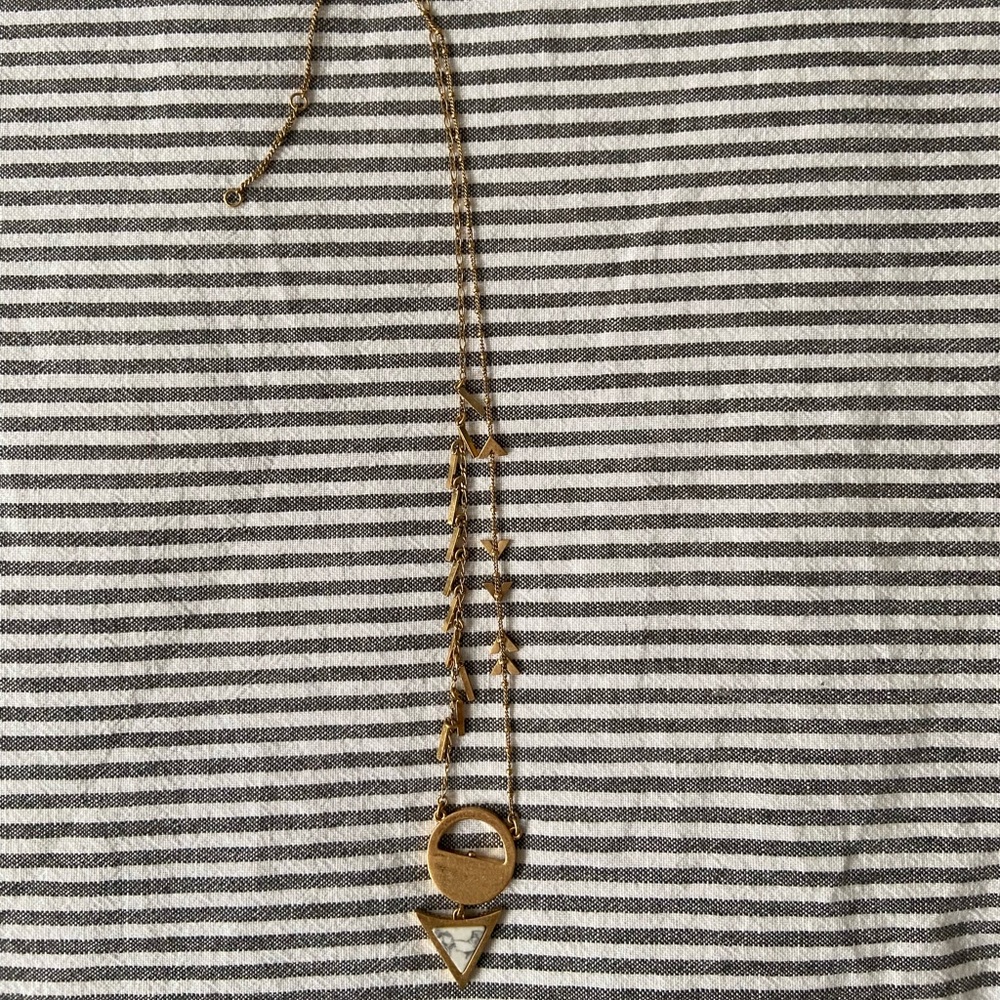 Gold-toned necklace with embellishments and reversible pendant.